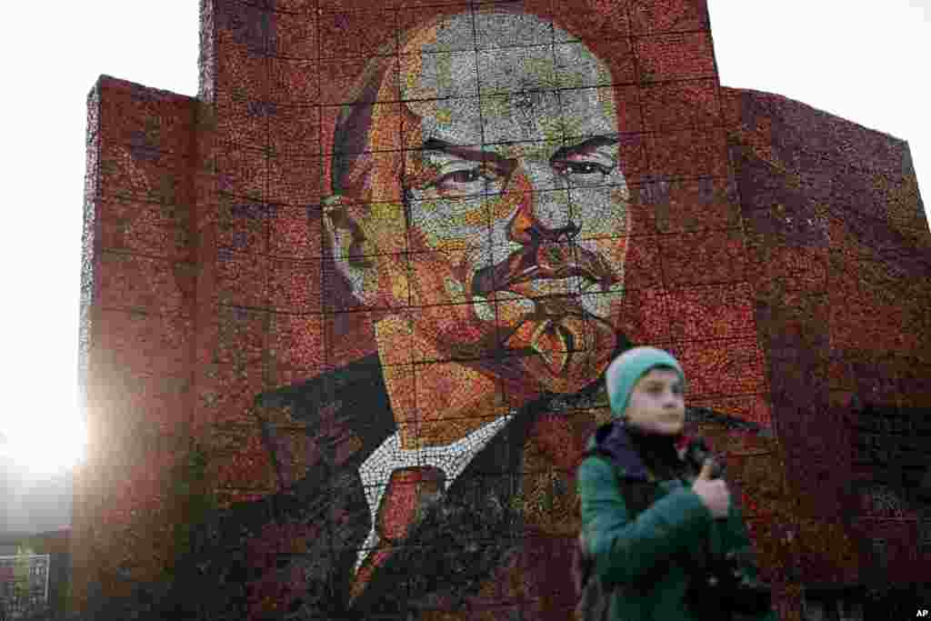 A boy pauses for photos in front of a mosaic portrait of Vladimir Lenin at the 2014 Winter Olympics, in Sochi, Russia,&nbsp;Feb. 20, 2014