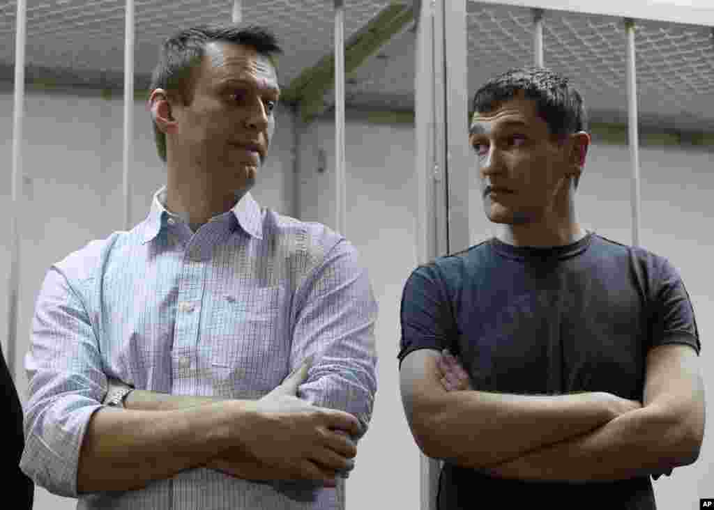 Russian opposition activist and anti-corruption crusader Alexei Navalny, 38, left, and his brother Oleg Navalny stand at a court in Moscow, Russia, Tuesday, Dec. 30, 2014.