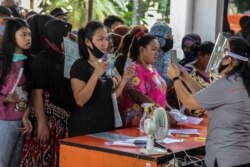 Sejumlah warga menerima bantuan langsung tunai di tengah pandemi virus corona di Medan, Sumatra Utara, 18 Mei 2020. (Foto: AFP)