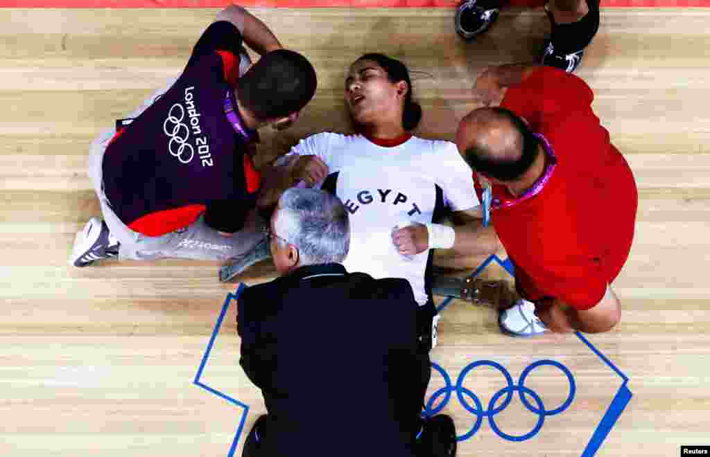 Egypt's Khalil K Abir Abdelrahman is assisted after failed attempt on the women's group A weightlifting competition.