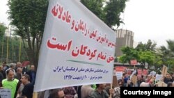 Dozens of retired and active Iranian teachers demonstrate outside Tehran's planning & budget office, May 10, 2018, to demand greater government funding for education. In this image provided to VOA Persian by an audience member, protesters hold a sign advocating free education for Iranian children. Iranian security forces later broke up the protest, beating and arresting several people.