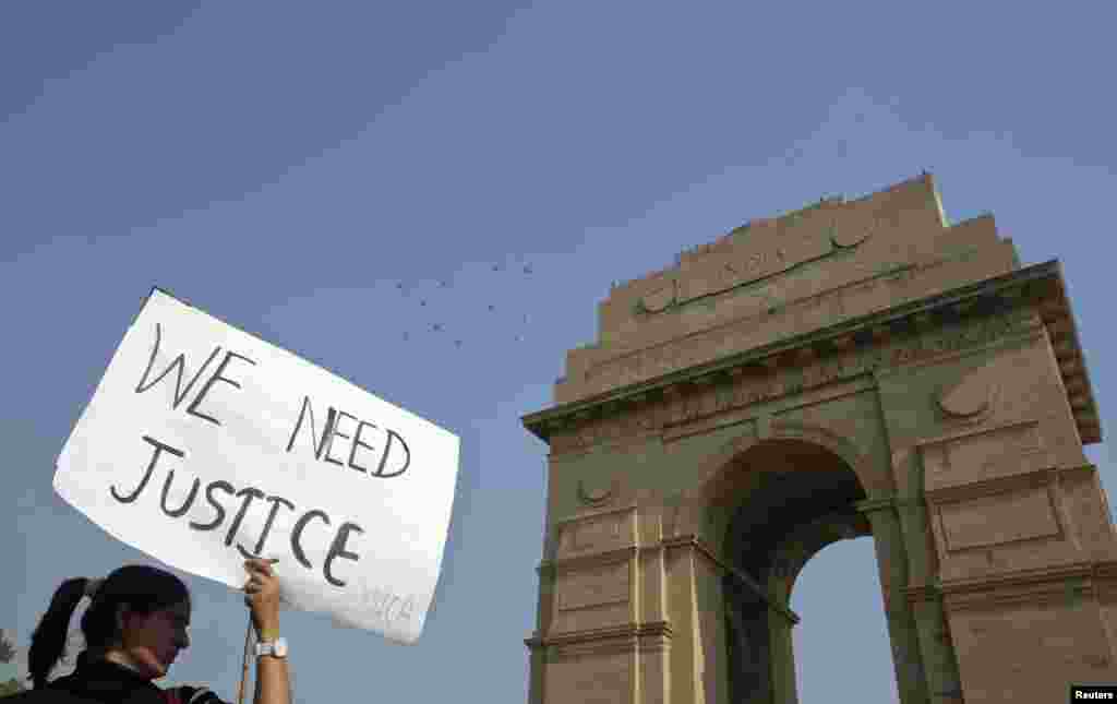 A demonstrator holds a placard in front of India Gate as she takes part in a protest rally organised by various women&#39;s organisations in New Delhi, India, December 21, 2012. 