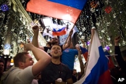 Russian soccer fans celebrate the national team victory after the group A match between Russia and Egypt during the 2018 soccer World Cup in Moscow, Russia, early on June 20, 2018..