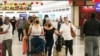 Travelers walk through Miami International Airport, Dec. 20, 2021, in Miami. 