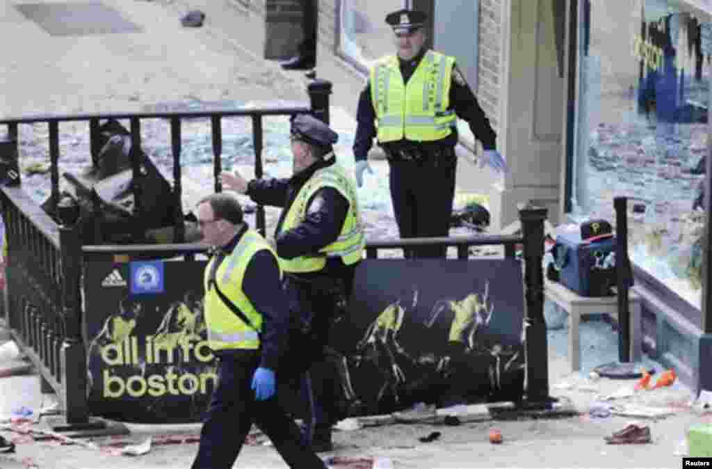 Pol&iacute;cia de Boston limpa uma &aacute;rea ap&oacute;s a explos&atilde;o perto da linha de chegada da Maratona de Boston 2013 (15 de Abril de 2013)