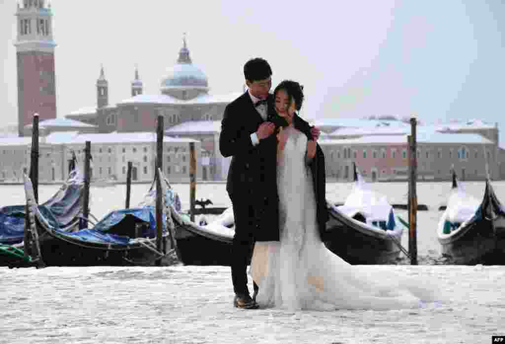 عکس گرفتن عروس و داماد در میدان سن مارکو پوشیده از برف در ونیز &nbsp;