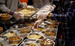 Suka relawan menyiapkan makanan untuk kegiatan amal berbuka puasa Ramadan di gereja Santa Anna, Barcelona, Spanyol, di tengah pandemi COVID-19, 28 April 2021. (REUTERS / Albert Gea)