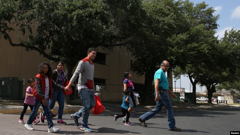 Eli Fernández (derecha), coordinador del centro de ayuda Caridades Católicas, ayuda a un grupo de inmigarntes indocumentados recientemente detenidos en una estación de autobús en McAllen, Texas, el 6 de abril, de 2018.