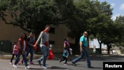 Eli Fernández (derecha), coordinador del centro de ayuda Caridades Católicas, ayuda a un grupo de inmigarntes indocumentados recientemente detenidos en una estación de autobús en McAllen, Texas, el 6 de abril, de 2018.