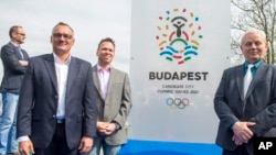 President of the Hungarian Olympic Committee Zsolt Borkai, left, Chairman of the Budapest 2024 bid Balazs Furjes, second left, and Budapest Mayor Istvan Tarlos, right, pose in front of the logo of host city candidate Budapest for the 2024 Olympic and Par