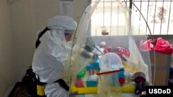 Letnan AL Jose Garcia dari AS menganalisa virus ebola dari laboratorium bergerak di Pulau Bushrod, Liberia (6/10).