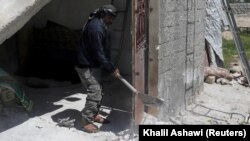 Taher al-Matar, 42, removes rubble from his damaged house in the rebel-held town of Nairab, Idlib region, Syria April 17, 2020. (REUTERS/Khalil Ashawi)