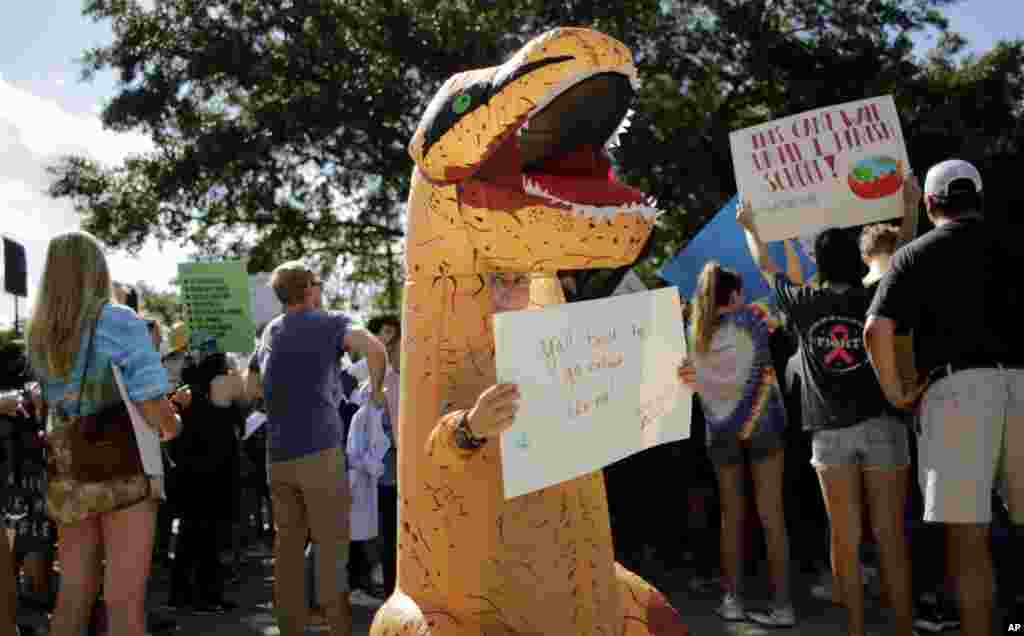این معترض در تظاهرات حامیان محیط زیست در تگزاس با پوشیدن لباس دایناسور می گوید اگر امروز اقدامی نشود، نسل انسانها مثل مانند دایناسورها منقرض می شود.&nbsp;