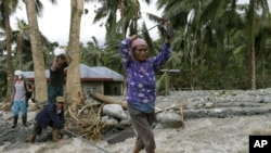 Residents cross a river using suspended ropes at Andap, New Bataan township, Compostela Valley in southern Philippines, Dec. 5, 2012, a day after Typhoon Bopha made landfall.