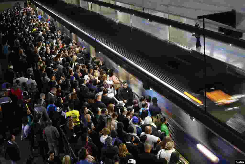 Commuters wait for the train at the Estacao da Se subway station in downtown Sao Paulo. Subway workers suspended a strike on Monday that crippled traffic in Brazil&#39;s largest city, but warned they could resume their walkout on Thursday, when Sao Paulo hosts the first game of the World Cup, June 10, 2014.