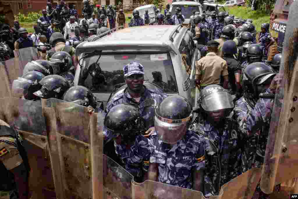 Police officers surround the car of Ugandan musician turned politician Robert Kyagulanyi, commonly known as Bobi Wine in Busabala. Bobi Wine was detained on his way to a press conference to announce the cancellation of his show.