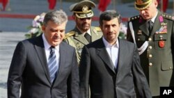Turkish President Abdullah Gul, left, is welcomed by his Iranian counterpart, Mahmoud Ahmadinejad, during welcoming ceremony for him, in Tehran, Iran, February 14, 2011