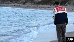 Un policier turc constate la mort d’un enfant syrien au large des côtes à Bodrum, au sud de la Turquie, le 2 septembre 2015. Une image devenue emblématique du drame des migrants en Méditerranée.