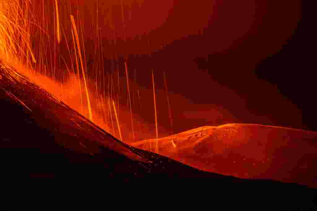 Streams of red hot lava flow as Mount Etna, Europe&#39;s most active volcano, erupts, as seen from Sant&#39;Alfio, Italy.