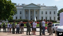 Demonstrators are lined up outside the White House in Washington, Aug. 28, 2014, as they are being arrested during a protest on immigration reform.