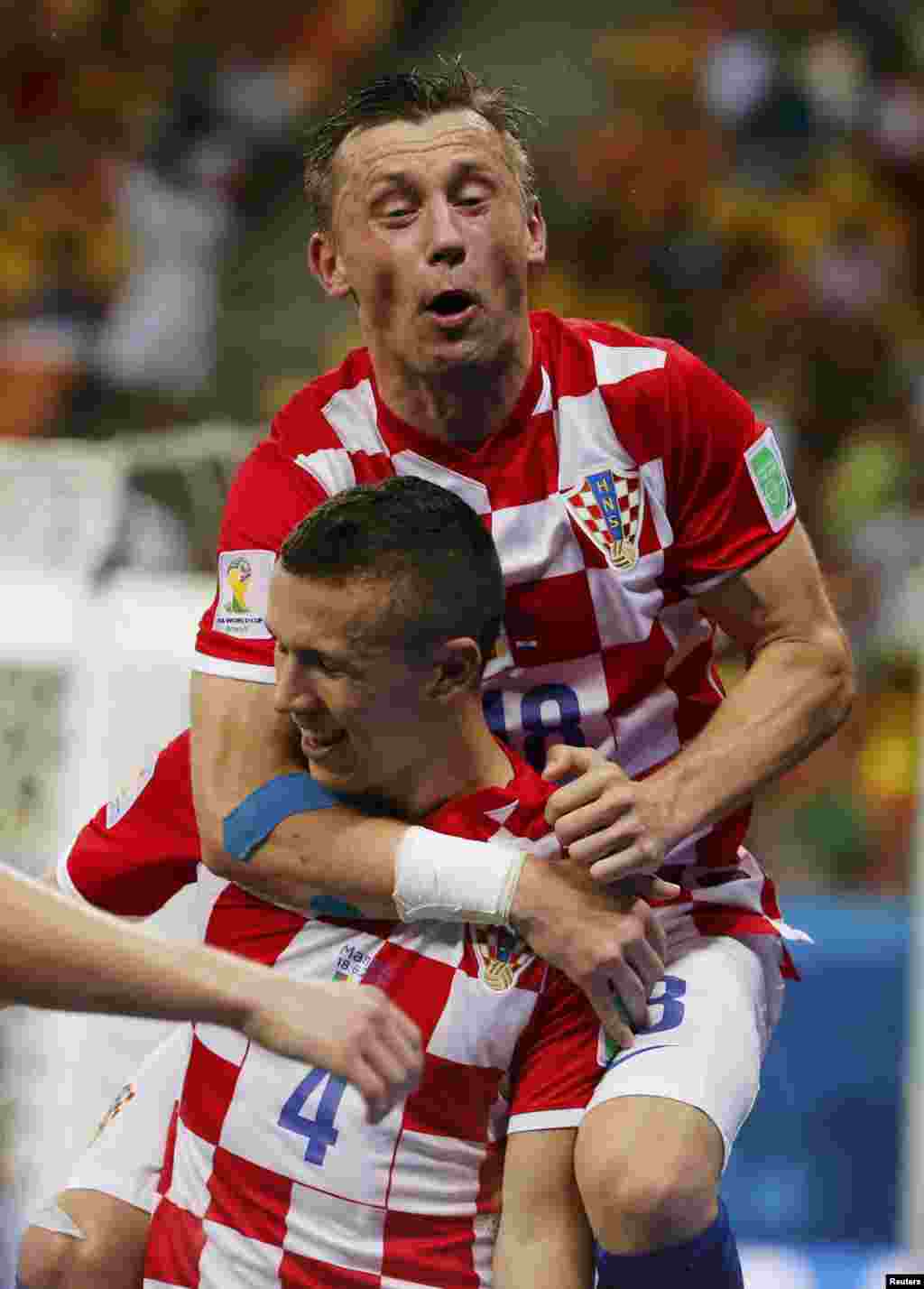 Croatia's Ivan Perisic celebrates after scoring a goal with teammate Ivica Olic (top) during their 2014 World Cup Group A soccer match against Cameroon, at the Amazonia arena, in Manaus, June 18, 2014.