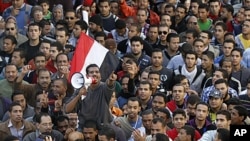 A demonstrator uses a portable loudspeaker as he shouts slogans against the military council during a mass protest in Alexandria, in support of mass protests in Tahrir square in Cairo, November 25, 2011.