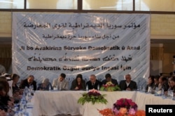 Participants attend a conference held by the Democratic Forces of Syria in Derek, Syria, Dec. 8, 2015. The text on the banner reads in Arabic, "Democratic Syria conference for Opposition forces, towards building a free democratic Syria."