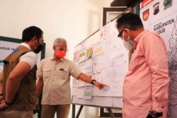 Gubernur Jawa Tengah Ganjar Pranowo (tengah) mengamati grafik kasus COVID-19 dalam kunjungan ke Kudus, Minggu 13 Juni 2021. (Foto: Courtesy/Humas Pemda Jateng)