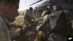 Afghan and U.S. soldiers rush an Afghan soldier, who was wounded in an IED explosion, into a U.S. helicopter (file photo)