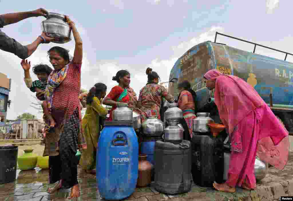 Local residents fill their empty containers with water from municipal corporation tanker on a hot summer day in Ahmedabad, India, May 30, 2016.