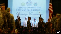 From left to right, U.S. Ambassador to the Philippines Sung Kim, Philippines Defense Chief Delfin Lorenzana, Undersecretary of Foreign Affairs Ariel Abadilla, stand at attention during the entry of colors at the opening ceremony for this year's joint Philippines-U.S. military exercise dubbed "Balikatan 2017", May 8, 2017.