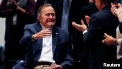 FILE - Former U.S. President George H. W. Bush arrives to hear a speech by his son, former President George W. Bush, at the George Bush Presidential Library Center in College Station, Texas, Nov. 11, 2014.