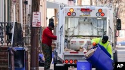 Municipal sanitation workers collect trash in Philadelphia, Jan. 13, 2022. 