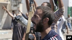 In this Sunday, Aug. 14, 2011 photo, a Libyan rebel fighter in Zawiya, western Libya, reacts to the news that the city of Surman, an important strategic point, is now under the control of the rebel forces.