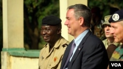 The Central African Republic's deputy chief of staff for planning, Lieutenant Colonel Ishmael Koagu, sits next to U.S. Ambassador to C.A.R. Jeffrey Hawkins during a ceremony when the ambassador turned over the keys to four cargo trucks. (Z. Baddorf/VOA)