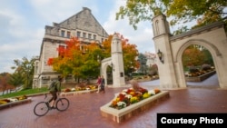 A student rides his bicycle across campus at Indiana University in Bloomington, Indiana.