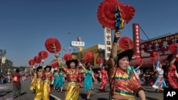 Dancers participate in the Chinatown's 119th annual Golden Dragon Parade to celebrate the Year of the Dog, with firecrackers, dragon, floats and bands in Los Angeles, Feb. 17, 2018. 