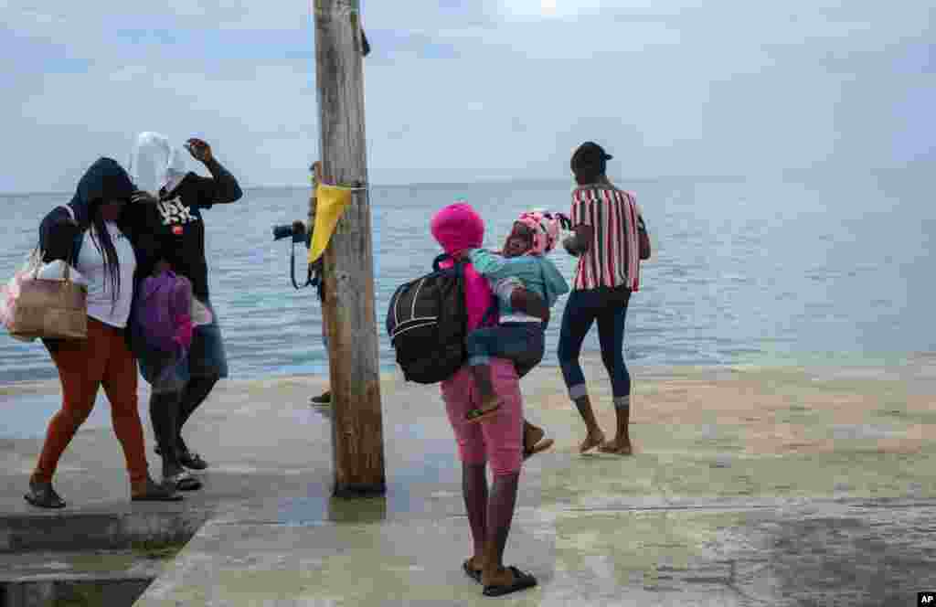 Una mujer lleva una niña en brazos tras ser evacuada del Cayo Sweeting's en Las Bahamas, el sábado, antes del paso del huracán Dorian. Gran Bahama, agosto 31 de 2019. AP/Ramón Espinosa.