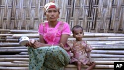 In this March 17, 2017, image made from video, Rosmaida Bibi, right, who suffers from severe malnutrition, sits with her 20-year old mother Hamida Begum outside their makeshift shelter at the Dar Paing camp, north of Sittwe, Rakhine State, Myanmar.