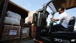 A lift truck driver offloads aid materials for Syria at the UNHCR warehouses in Dubai.