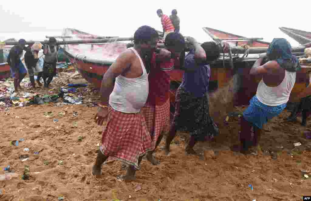 Indian fishermen pull a boat to higher ground on a beach in Puri in the eastern Indian state of Odisha as Cyclone Fani approaches the Indian coastline.