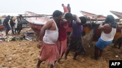 Indian fishermen pull a boat to higher ground on a beach in Puri in the eastern Indian state of Odisha on May 2, 2019, as cyclone Fani approaches the Indian coastline.