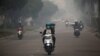Para pengendara sepeda motor mengenakan masker saat melintasi jalanan di Palangkara Raya, Kalimantan tengah, yang diselimuti oleh kabut asap akibat kebakaran hutan, 15 September 2019. (Foto: dok).
