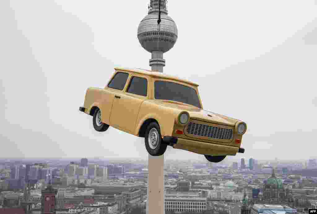 The likeness of a Trabant, east Germany&#39;s iconic car, is suspended over a Berlin skyline with its landmark the TV tower during a publicity stunt for an amusement park. 