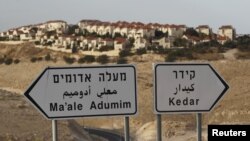 在标示牌后面可见耶路撒冷附近约旦河西岸的犹太人定居点