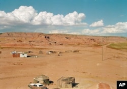 FILE - An isolated Navajo home located in a small canyon east of Tuba City, Ariz., Aug. 30, 1993. Many Navajo don't have street addresses, a requirement for voting in Arizona. (AP Photo/Jeff Robbins)