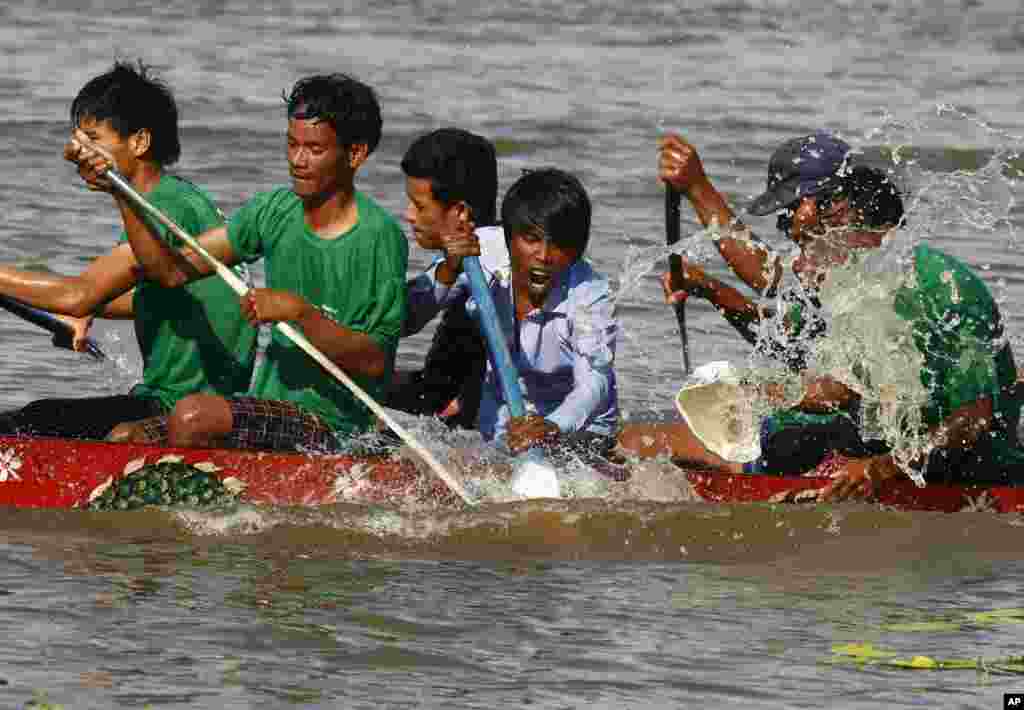 Competitors row their wooden boat during a boat racing as part of celebrations of the Water Festival in Thnol Dach, Takoe province, southwestern Cambodia.