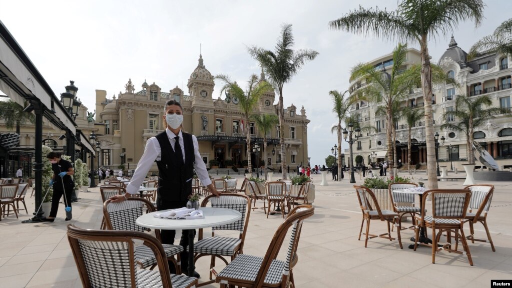 A waiter wearing a face mask serves at Cafe de Flore, as restaurants and cafes reopen following the coronavirus disease (COVID-19) outbreak, in Paris, France,