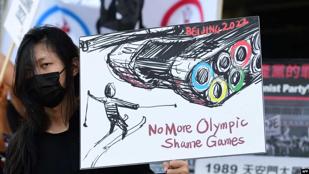 一名女子站在中国驻洛杉矶领事馆前手举标语牌呼吁抵制北京冬奥会。（2021年11月3日）(photo:VOA)