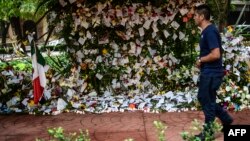 A man passes by messages placed in an offering to the victims of Mexico City's earthquake, Sept. 25, 2017. 